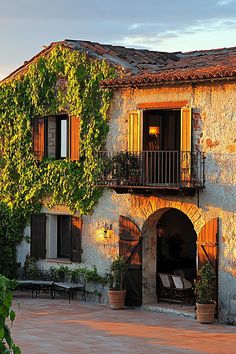 Stone house with ivy and charming balcony basking in warm sunlight. Embark on a whirlwind tour of luxurious abodes where opulence meets whimsy, leaving you green with envy and ideas for your next home upgrade.