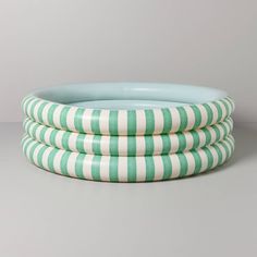 three green and white striped plates stacked on top of each other