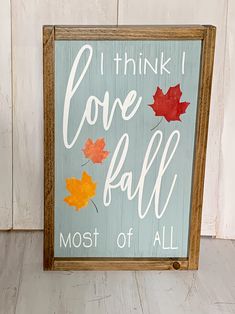 a sign that says i think i love fall most of all with leaves on it