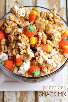 pumpkin snack mix in a glass bowl with candy corn and jack - o'- lantern candies