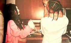 two women standing in a kitchen next to each other and one has her hair pulled back