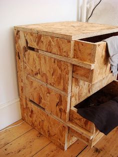 a wooden dresser sitting on top of a hard wood floor next to a white wall