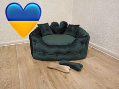 a green chair with a blue heart on the back and a pair of shoes next to it