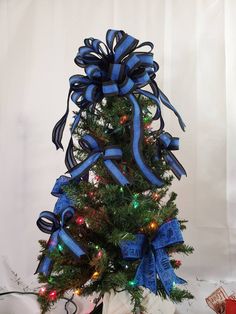 a small christmas tree with blue ribbon and lights