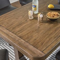 a wooden table with two bowls of food on it and bottles of water next to it