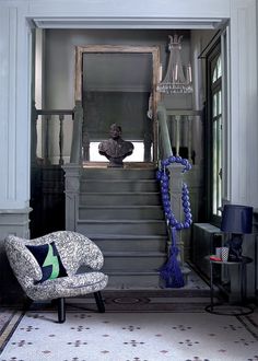 a chair sitting on top of a carpeted floor next to a stair case in a living room