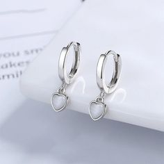 OPAL HEART HUGGIE HOOP EARRINGS IN STERLING SILVER Welcome to Exquisite by Kate, where elegance meets personalisation! Discover our stunning silver opal heart huggie earring set. This timeless set is the perfect accent piece for your outfit--a piece that beautifully combines sentiment and style. ✨ Why You'll Love It: Unique & Bespoke, perfect for the every day look or for that special occasion.  🌟 Exquisite by Kate Promise: As a new, family-run business, we pour our hearts into every item we of Huggie Earring, Minimalist Accessories, Huggie Hoop Earrings, Third Party, Huggies Earrings, Heart Earrings, Personalized Jewelry, Heart Pendant, Statement Earrings