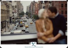 a man and woman standing in the middle of a city street looking out at traffic