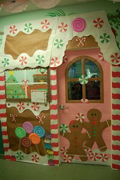 a gingerbread house decorated with candy canes and candies on the front door