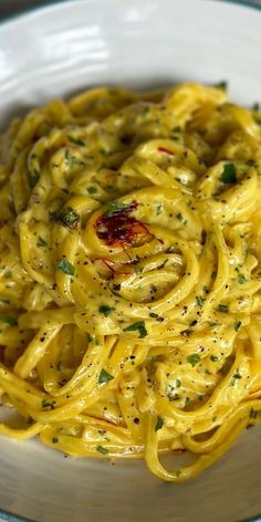 a white plate topped with pasta covered in sauce and parmesan sprinkles