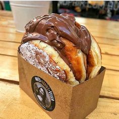 a chocolate covered pastry in a brown paper box