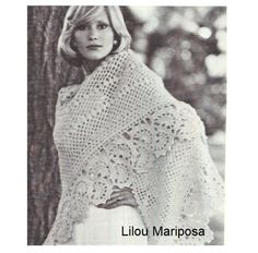 a woman wearing a white shawl standing next to a tree