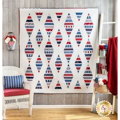 a quilt hanging on the wall next to a chair