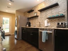 a kitchen with stainless steel appliances and black cabinets is pictured in this image from the inside