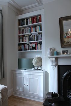 a living room filled with furniture and a fire place next to a bookshelf