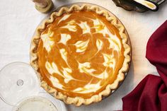 a pie sitting on top of a table next to some wine glasses and other items