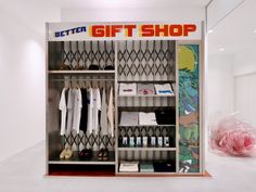 an open closet with clothes and shoes on display in a room that has a sign saying, better gift shop