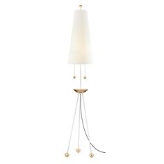 a floor lamp with a white shade on the top and two gold balls hanging from it