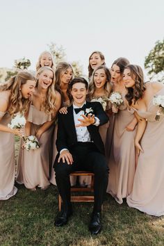 a group of bridesmaids pose for a photo with the groom in a tuxedo