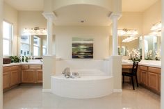 a large white tub sitting inside of a bathroom