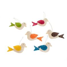 four small birds hanging from strings on a white background, each with different colors and shapes