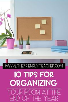 an office desk with pink flowers and sticky notes on the bulletin board in front of it