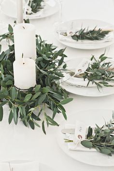 the table is set with candles and greenery