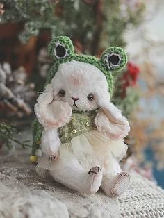 a white stuffed animal sitting on top of a table next to a christmas ornament