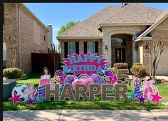 a happy birthday sign in front of a house with a girl standing next to it