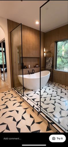 a bathroom with a large white bath tub sitting next to a walk in shower stall