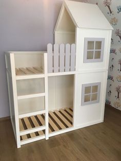 a white doll house with wooden floors and walls