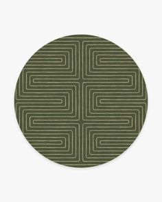 a round rug with an abstract design in green and white on the side, against a white background