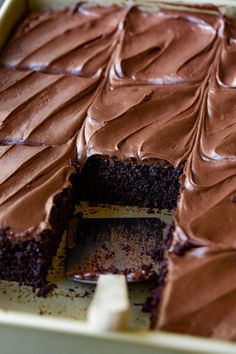 a chocolate cake that has been cut into pieces and is sitting in a pan with one slice missing