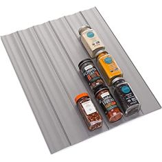 spices and seasonings are lined up next to each other on a gray mat,