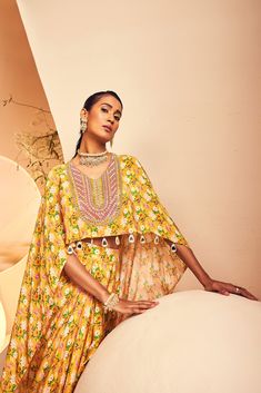 featuring a high-low top paired with a draped dhoti skirt in a modern floral print. The neckline is embroidered fully by hand with intricate Japanese cutdana and bead embroidery. From Aneesh Agarwaal's Naksh collection. DELIVERY TIMEPlease allow 8-12 weeks for your outfit to arrive. FABRIC DETAILSCrepe Professional cleaning only. Bollywood Style Floral Print Sets With Traditional Drape, Bollywood Floral Print Sets With Traditional Drape, Georgette Dresses With Traditional Drape And Printed Motifs, Festive Tunic Sets With Embroidered Neckline, Festive Bollywood Dress With Embroidered Neckline, Bohemian Anarkali Set With Floral Embroidery, Bohemian Embellished Lehenga With Traditional Drape, Floral Embroidered Dresses For Navratri In Traditional Drape, Bollywood Style Dresses With Embroidered Neckline