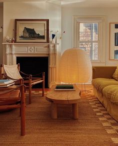 a living room filled with furniture and a lamp on top of a wooden coffee table