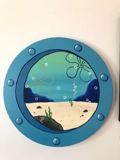 a blue porthole with an octopus and seaweed in the water on it's side