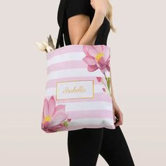 a woman carrying a pink and white striped tote bag with flowers on the side