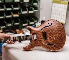 a man is playing an electric guitar on a table