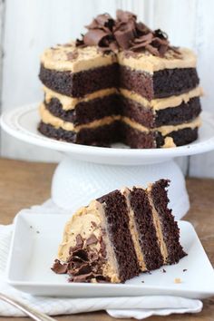 there is a piece of chocolate cake on the plate and another slice has been cut