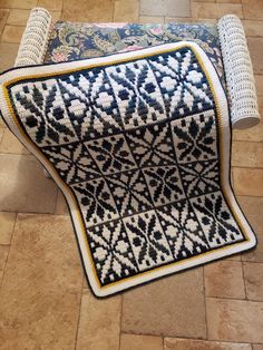 a blue and white rug sitting on top of a tiled floor