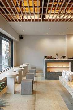 the interior of a restaurant with tables and stools in front of a large window