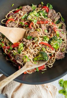 stir fry with beef, broccoli and peppers in a wok on the table