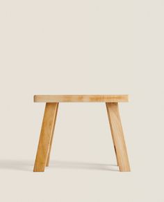 a small wooden bench sitting on top of a white floor