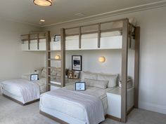 two beds in a room with bunk beds on each side and shelves above the bed