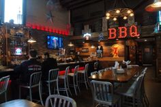 a bar with several tables and chairs in front of the bar area at bbq