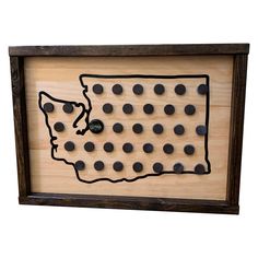 a wooden board with black dots in the shape of a state