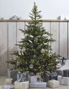 a small christmas tree with presents under it