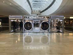 people are standing in front of the washer machines at the store's entrance