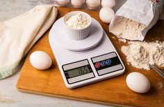 an electronic scale with eggs and flour on it